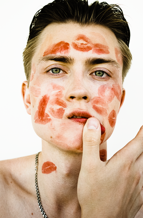 Free Close-up of a young man with multiple lipstick kiss marks on his face. Stock Photo