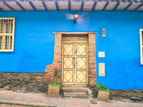 Free Colorful colonial architecture with a vibrant blue wall and traditional door in Bogotá, Colombia. Stock Photo