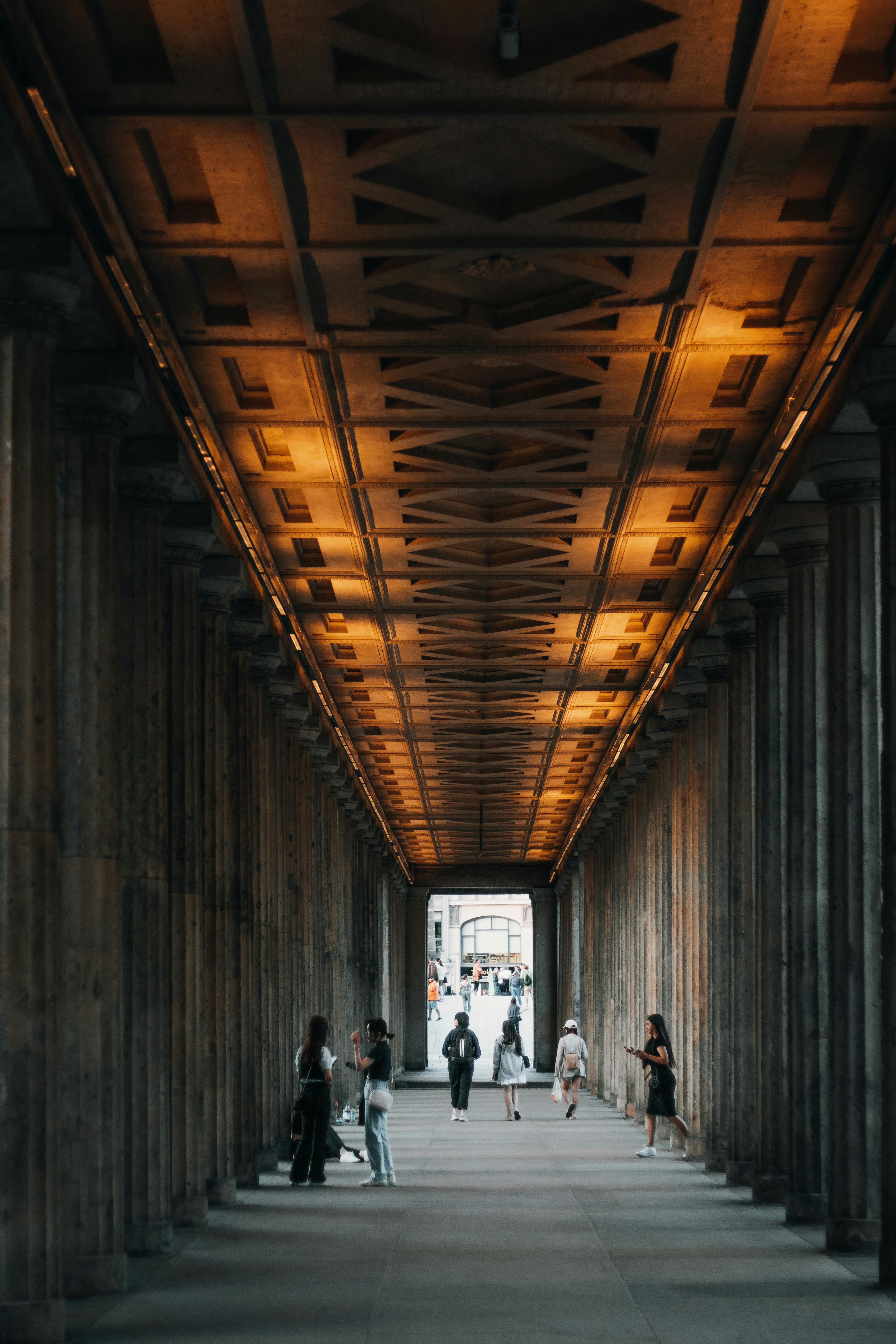 View of people walking through a historic urban passageway in Berlin, Germany.