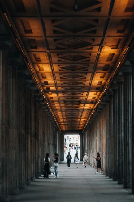 View of people walking through a historic urban passageway in Berlin, Germany.