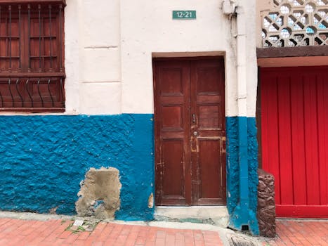 Colorful wooden door and vibrant wall in Bogotá, Colombia showcasing urban architecture.
