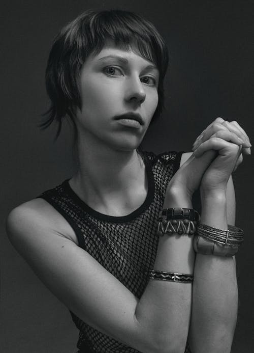 A Grayscale Photo of a Woman in Black Tank Top Wearing Bangles