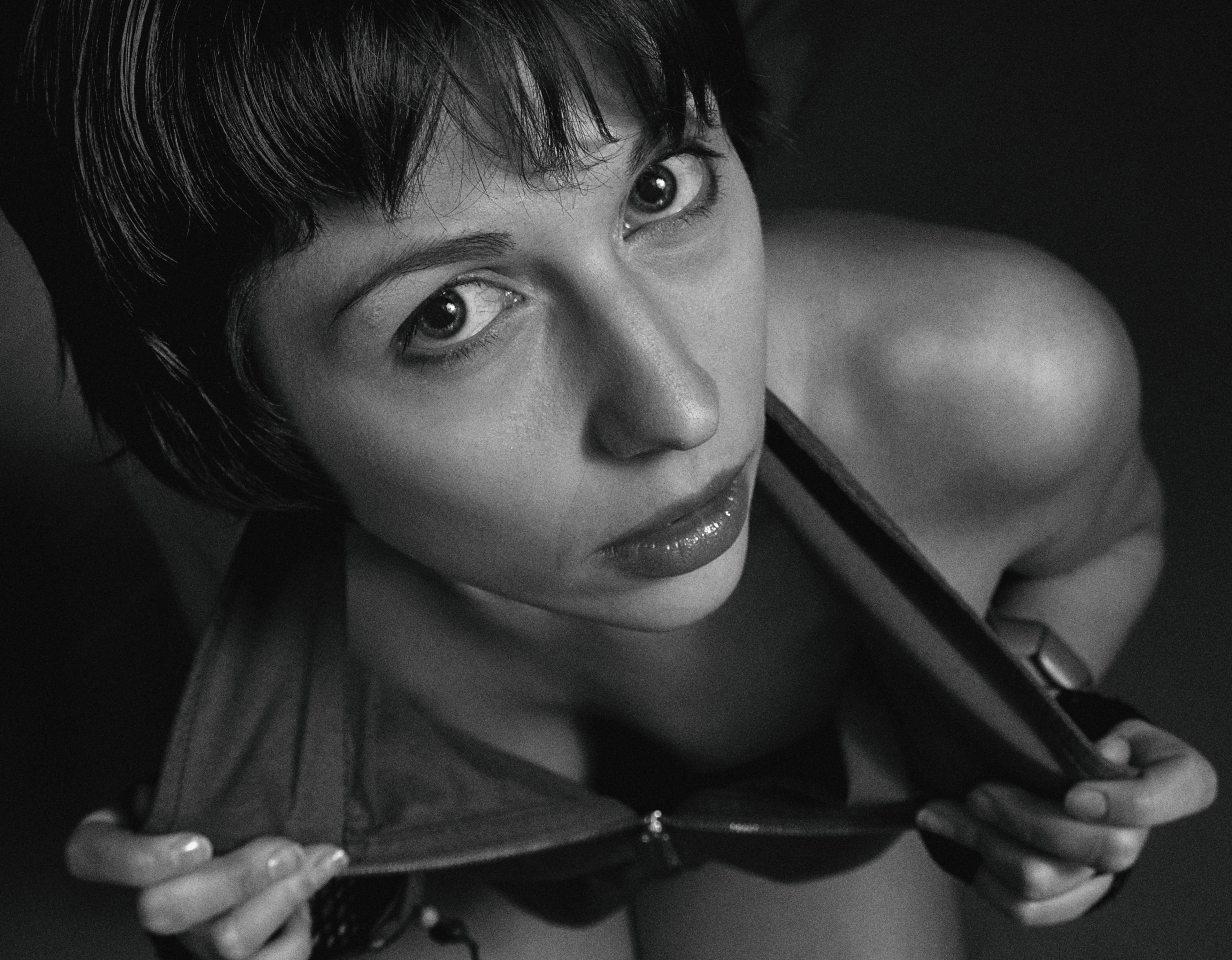 Artistic black and white portrait featuring a woman gazing upwards, capturing emotion and depth.