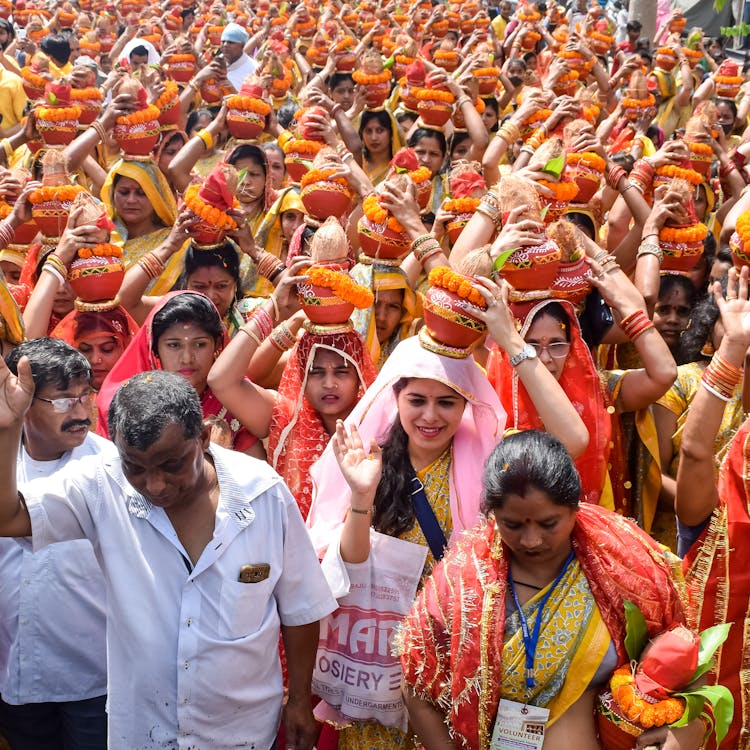 Crowd Holding Vases On Heads