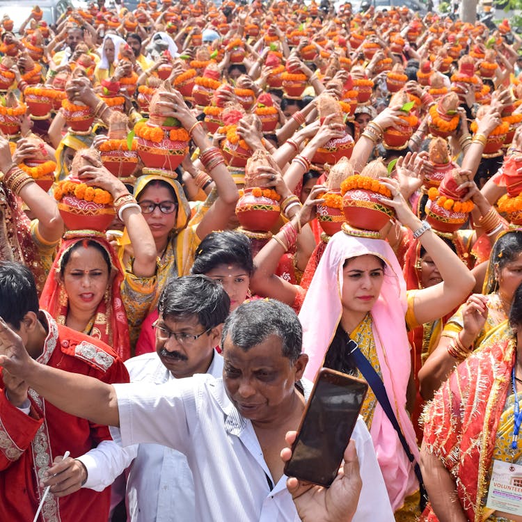 Crowd On Gathering Holding Vases On Heads