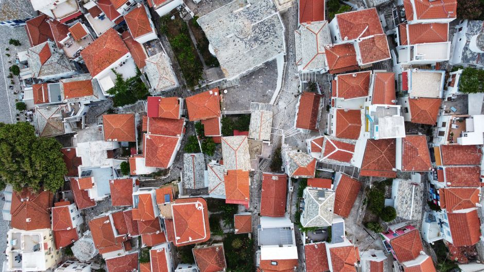 Stunning Private Helicopter Transfer from Athens to Costa Navarino Review 2026 - Aerial view of Skopelos town showcasing red tiled rooftops and narrow streets, capturing Greek island architecture.
