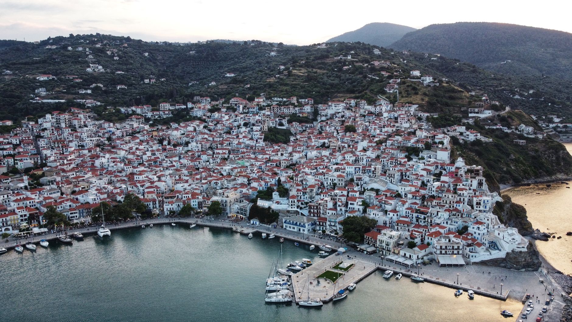Aerial view of the harbour and wooded coastline of Skopelos, Greece.