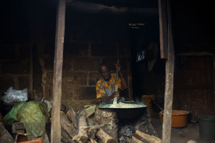 Man Stirring Food In A Large Cooking Pot