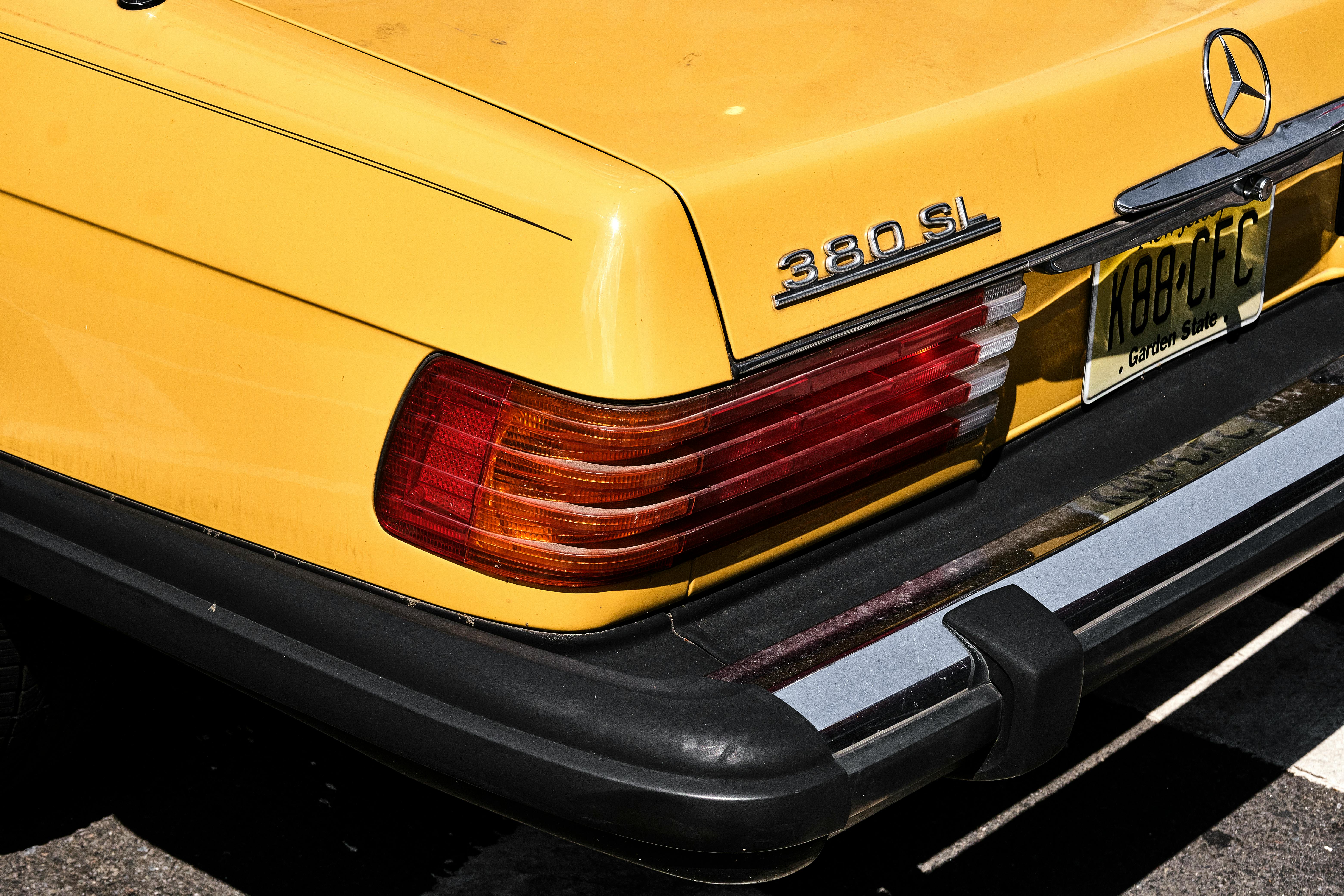 Close-up of a yellow vintage car's rear with a New Jersey license plate.