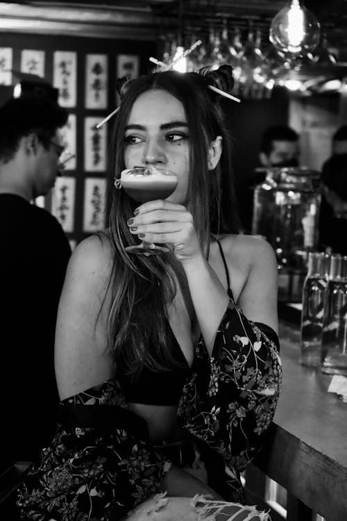 Grayscale Photo of a Sexy Woman in the Bar Holding a Cocktail Drink