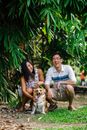 Adult Tan and White Pembroke Welsh Corgi Sitting Between Couple