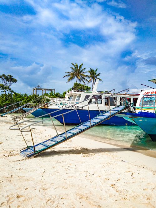 Free Boats docked on the pristine white sand beach of Boracay, Philippines, under a clear sky. Stock Photo
