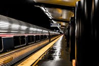 夜晚，一列时尚的列车停靠在灯火通明的站台，地面上映着潮湿的倒影