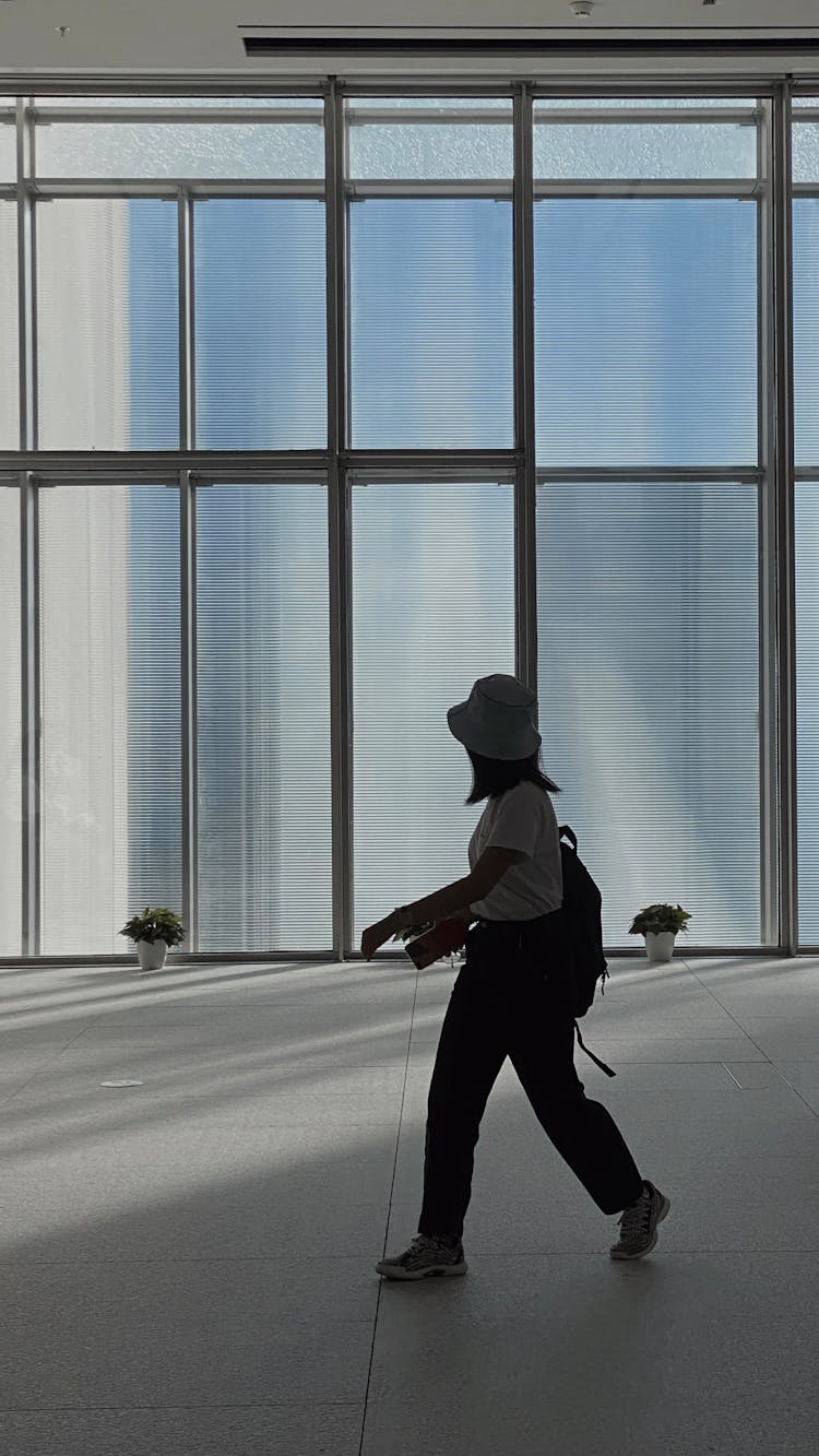 Woman Walking Past Glass Wall