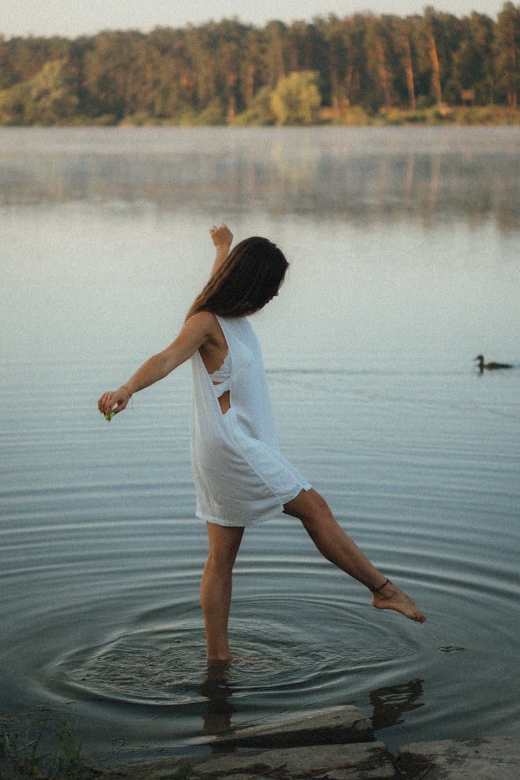 Brunette Walking In Lake On Summer Day