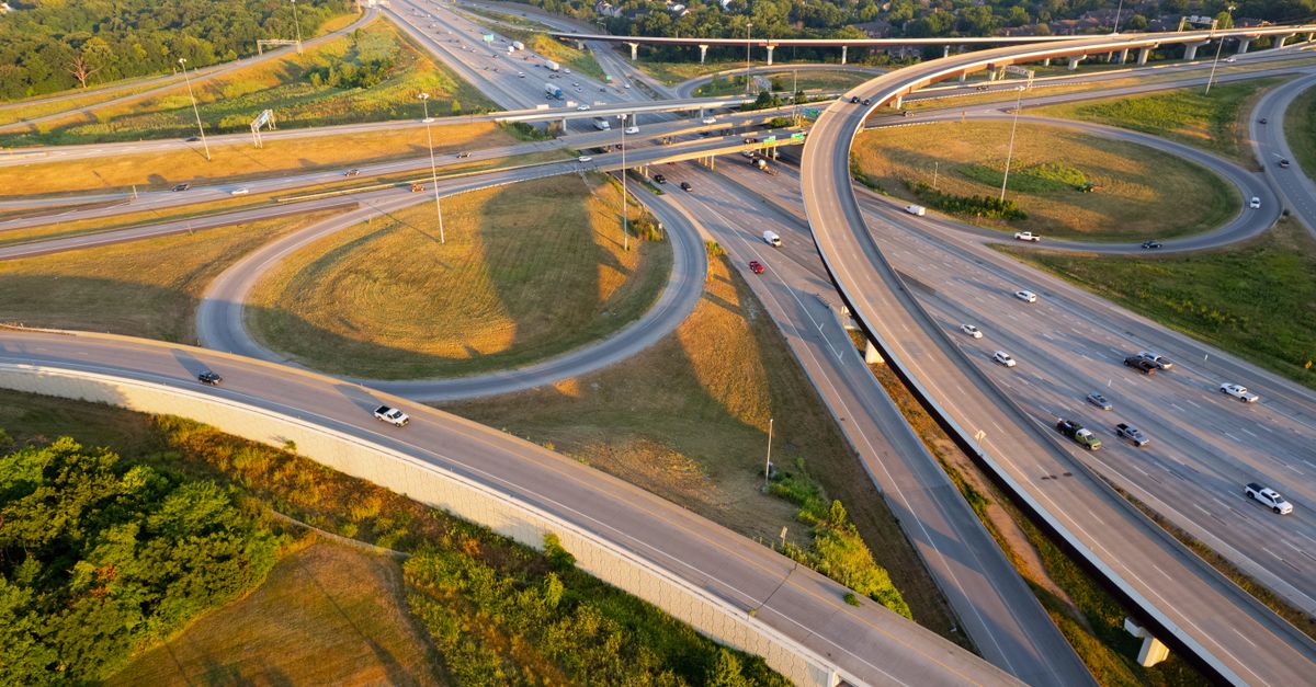 Stunning aerial shot of a highway interchange in Overland Park, Kansas during golden hour, showcasing intricate road networks.