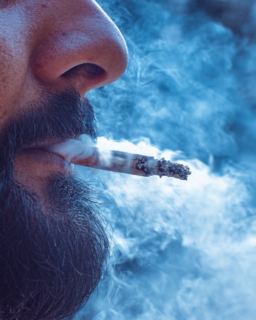 Close-Up Shot of a Bearded Man Smoking Cigarette