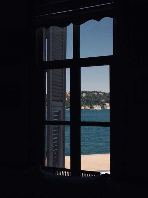 Free A serene view of the Bosphorus Strait seen through a window frame, capturing tranquility. Stock Photo
