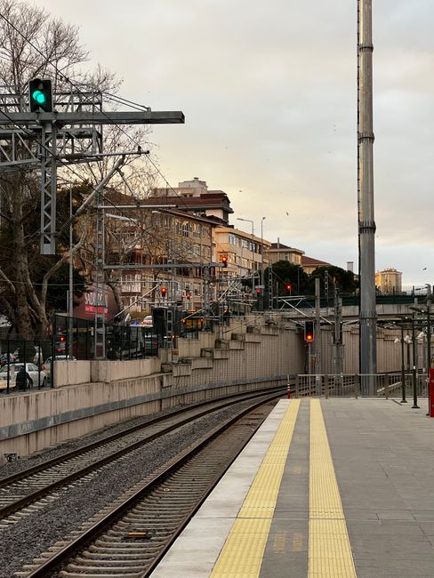 Empty railway platform with city backdrop during daytime.