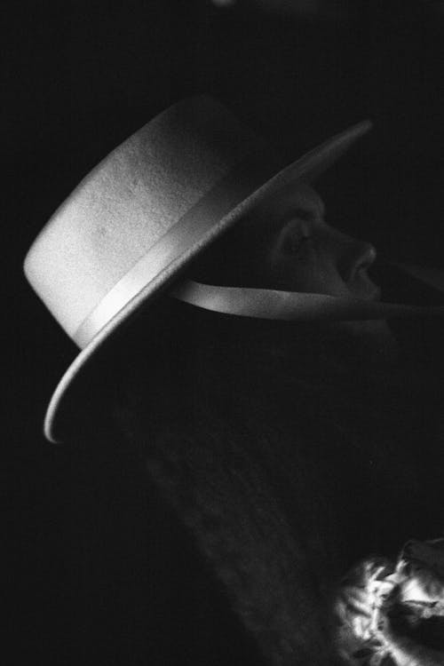 Grayscale Photo of Person Wearing Boater Hat