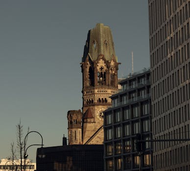 View of Kaiser Wilhelm Memorial Church amid modern buildings, blending historic and contemporary architecture.