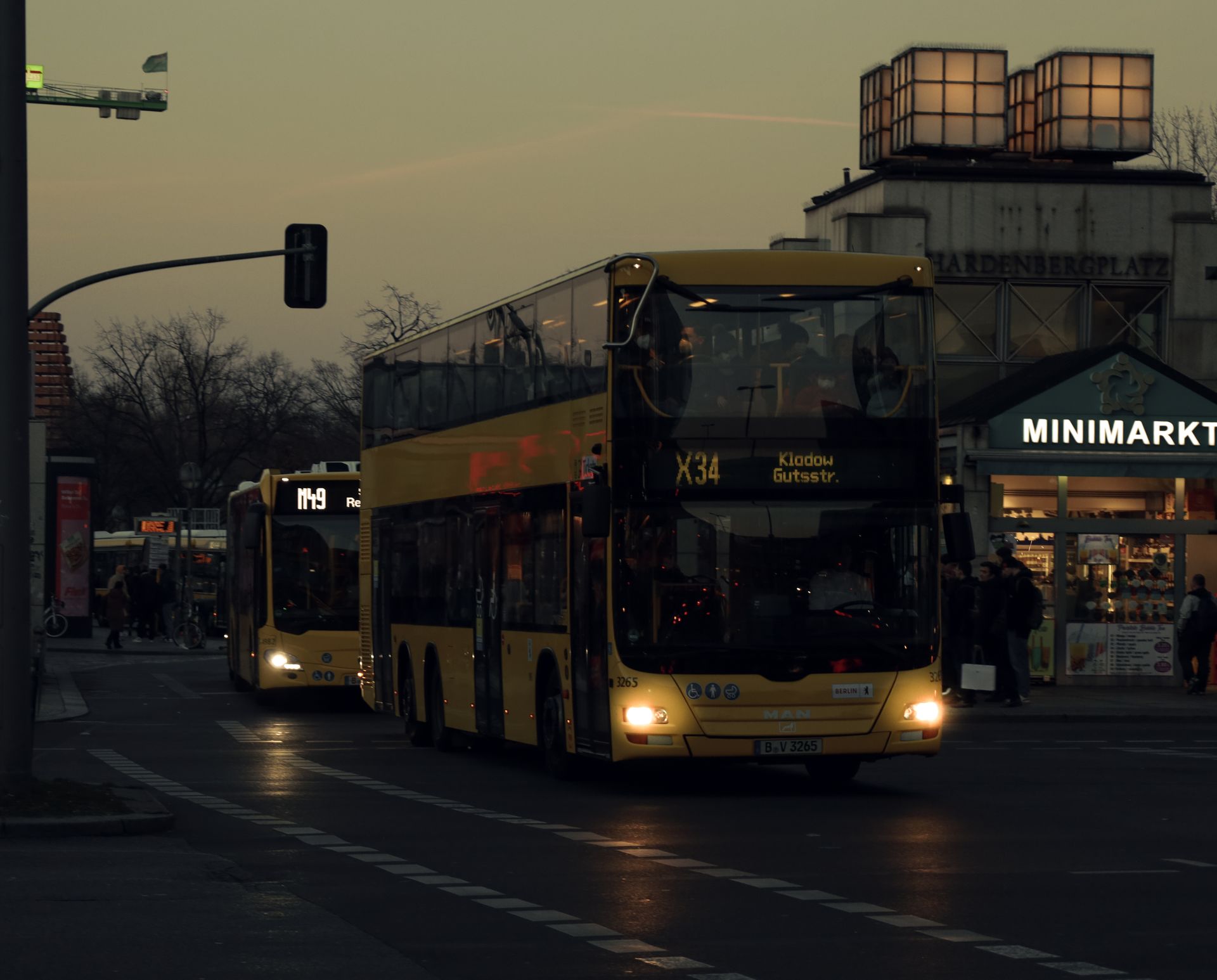 Double decker bus on city street at dusk, showcasing urban transportation.