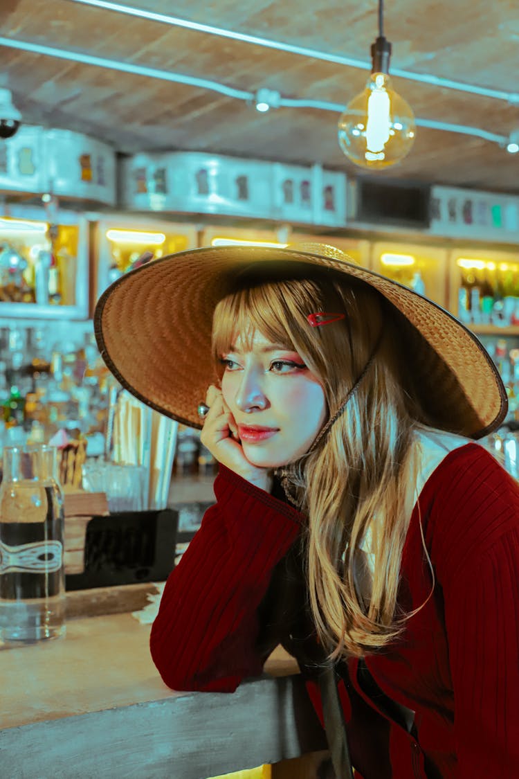 Portrait Of A Blonde Woman In Wearing A Traditional Japanese Hat In A Bar