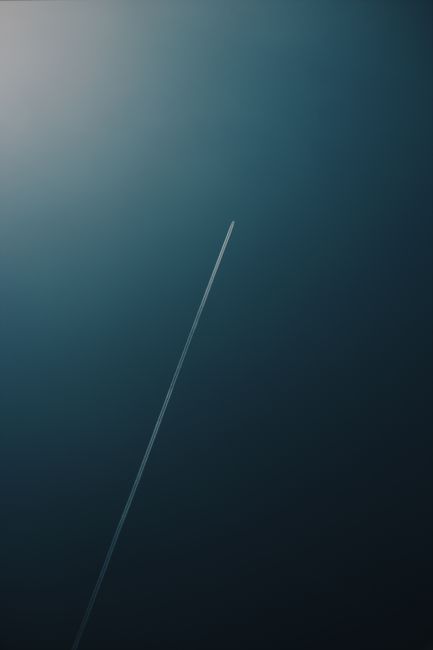 Aviation contrail streaks across the clear sky over Rio de Janeiro.
