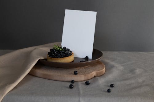 A Blueberry Tart on a Ceramic Plate with White Paper
