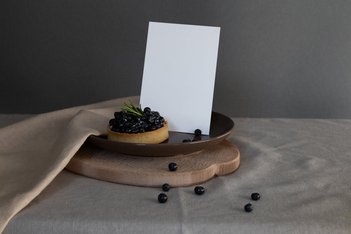 A Blueberry Tart on a Ceramic Plate with White Paper