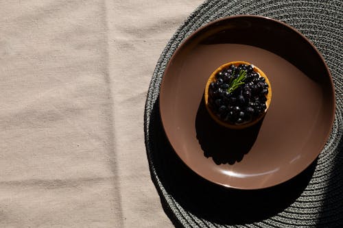 A Blueberry Tart on a Brown Ceramic Plate