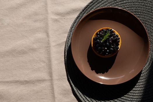 A Blueberry Tart on a Brown Ceramic Plate