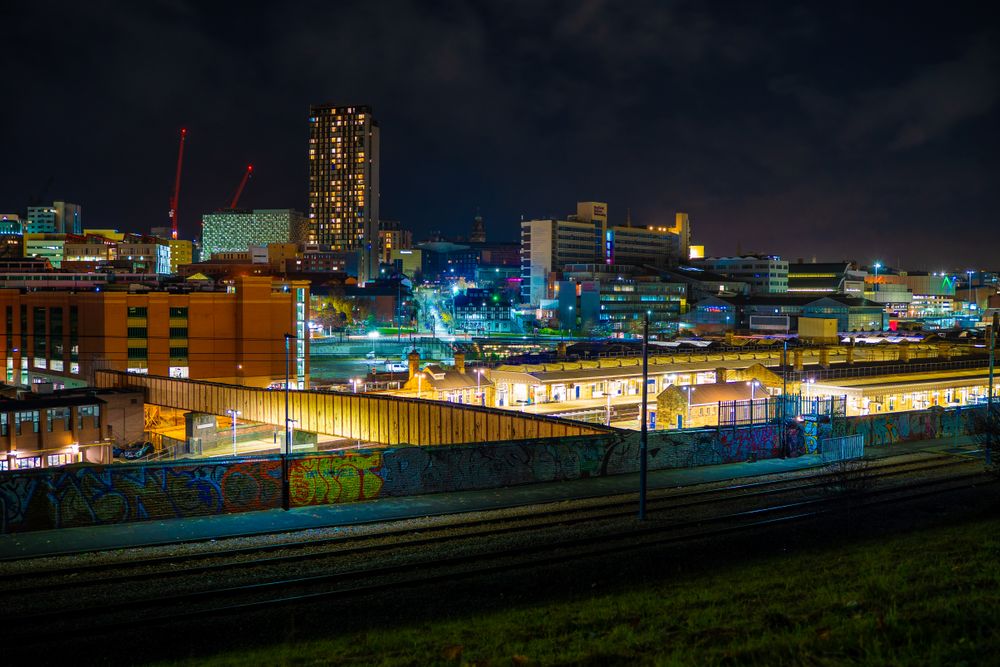 Illuminated night view of Sheffield cityscape showcasing modern architecture and urban life.