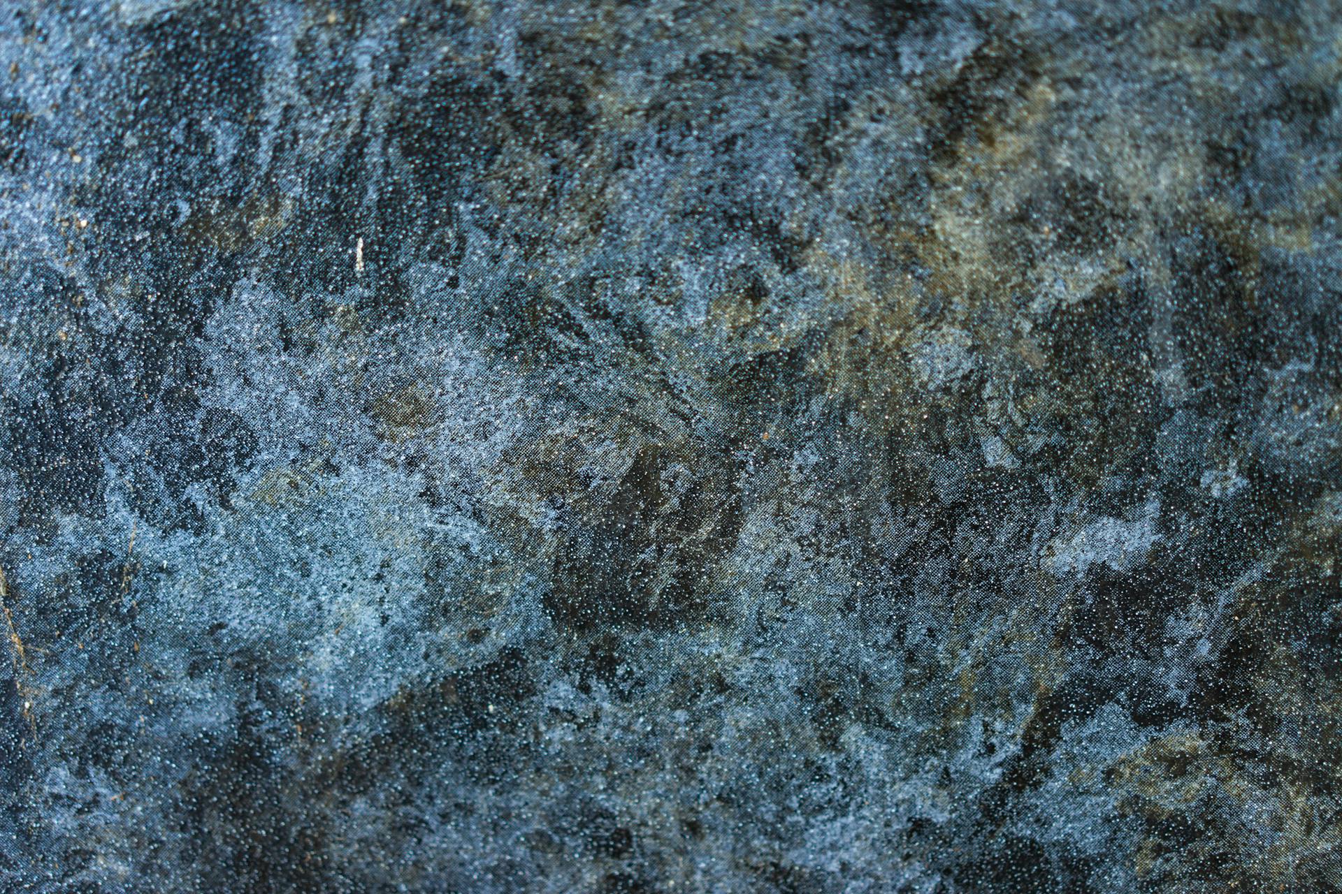 Detailed close-up of a rough, textured stone surface with blue and gray tones.