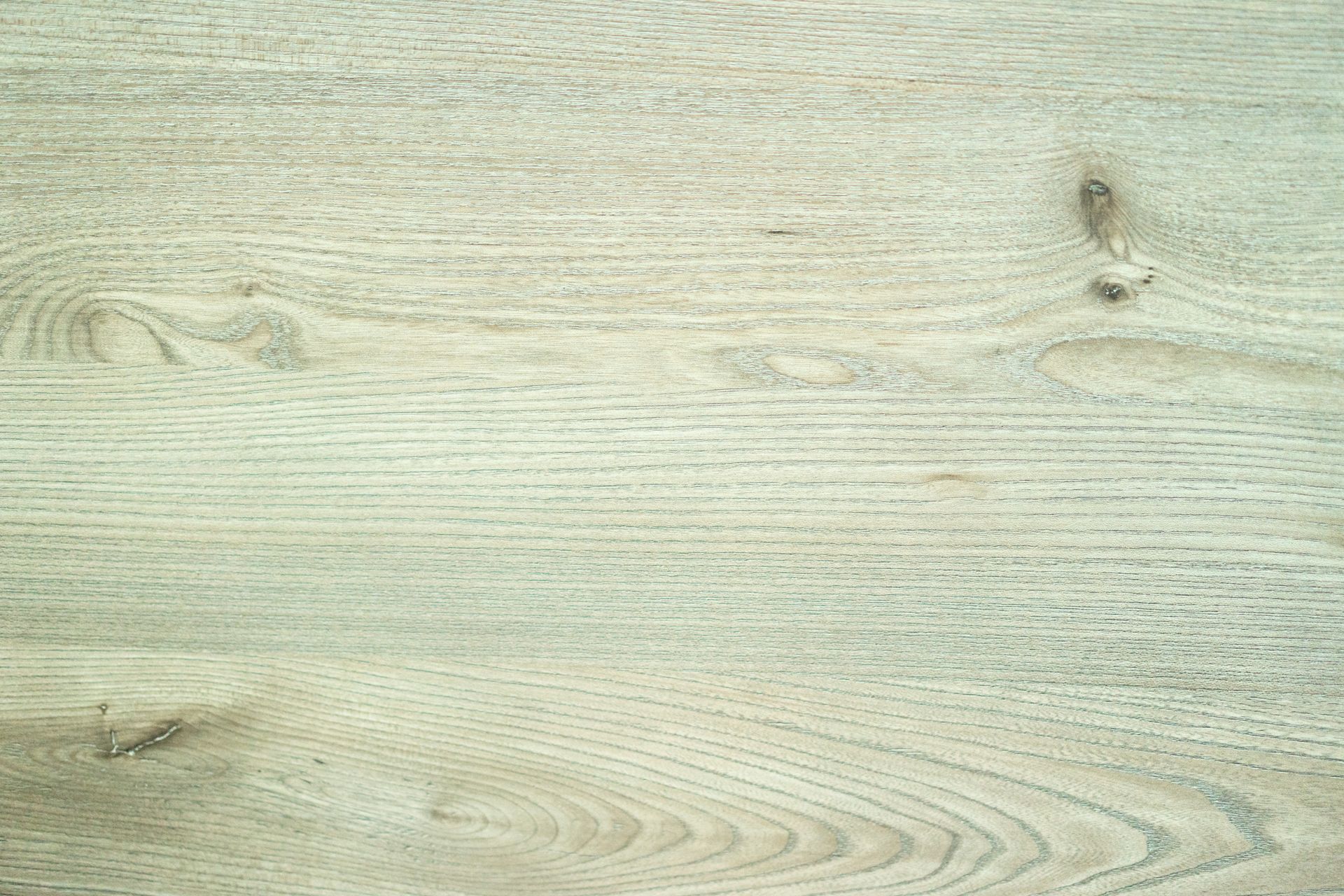 A detailed close-up of a natural wooden texture showing grain and knots.