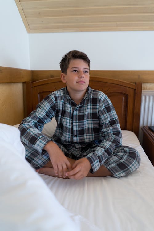 Free A Boy Sitting on the Bed  Stock Photo