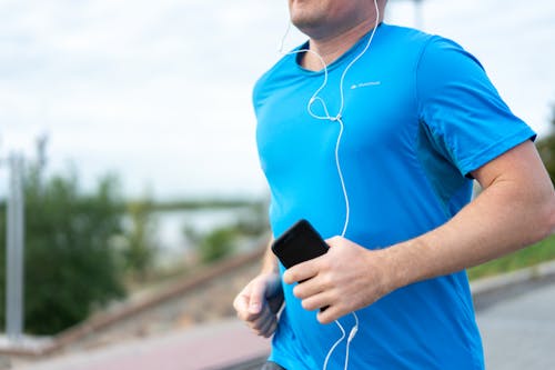 Man Jogging with a Smart Phone in his Hand 