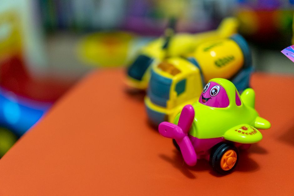 A vibrant toy airplane and concrete mixer on an orange table, creating a playful scene.