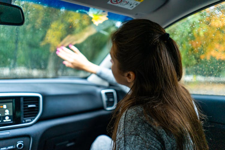 Woman Sitting In Car In Rain