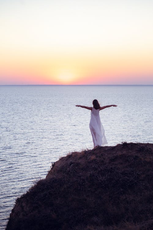 Woman in White Dress Standing on Hilltop 