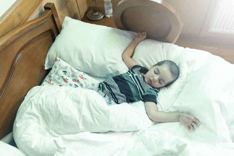 A Boy Sleeping On Bed