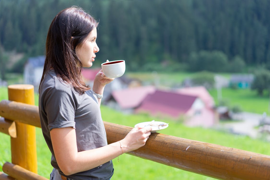 Woman in Gray Crew Neck T-shirt Holding White Ceramic Mug