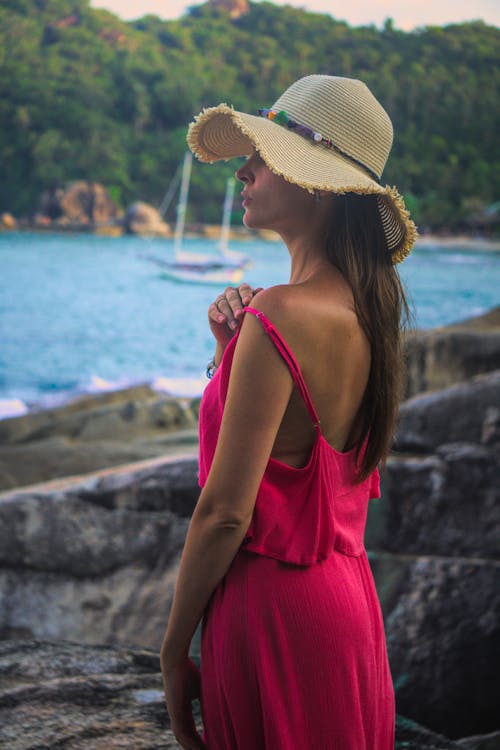 Photo of a Woman in a Pink Dress Wearing a Hat