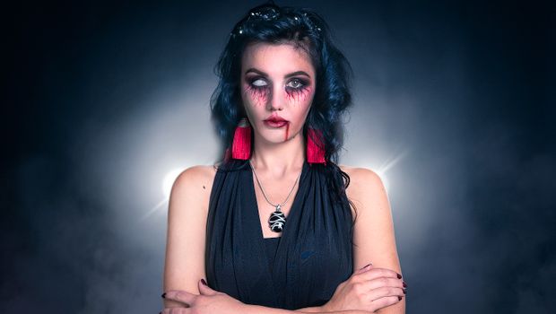 Close-up of a woman's spooky Halloween look featuring creepy makeup and fake blood.