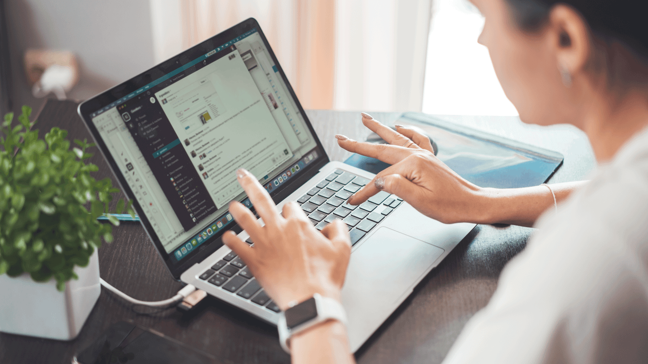 A woman working on a laptop from home, focusing on digital tasks and communication.
