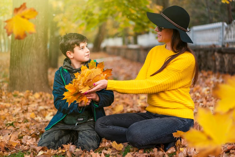 Woman Giving Leaves To A Boy