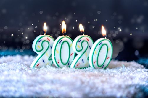 Free Colorful 2020 number candles lit on a snowy surface, symbolizing a festive celebration. Stock Photo