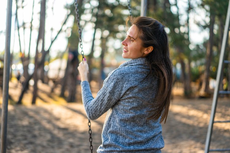 Happy Woman On Swing In Park