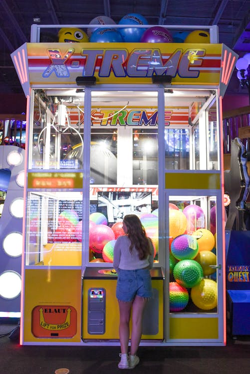 Free Woman Standing in Front of X-treme Arcade Machine Stock Photo