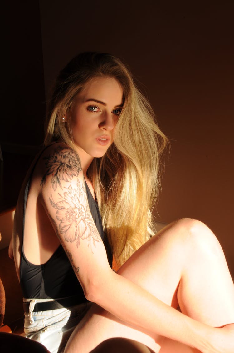 A Woman In Black Tank Top With Arm Tatoo